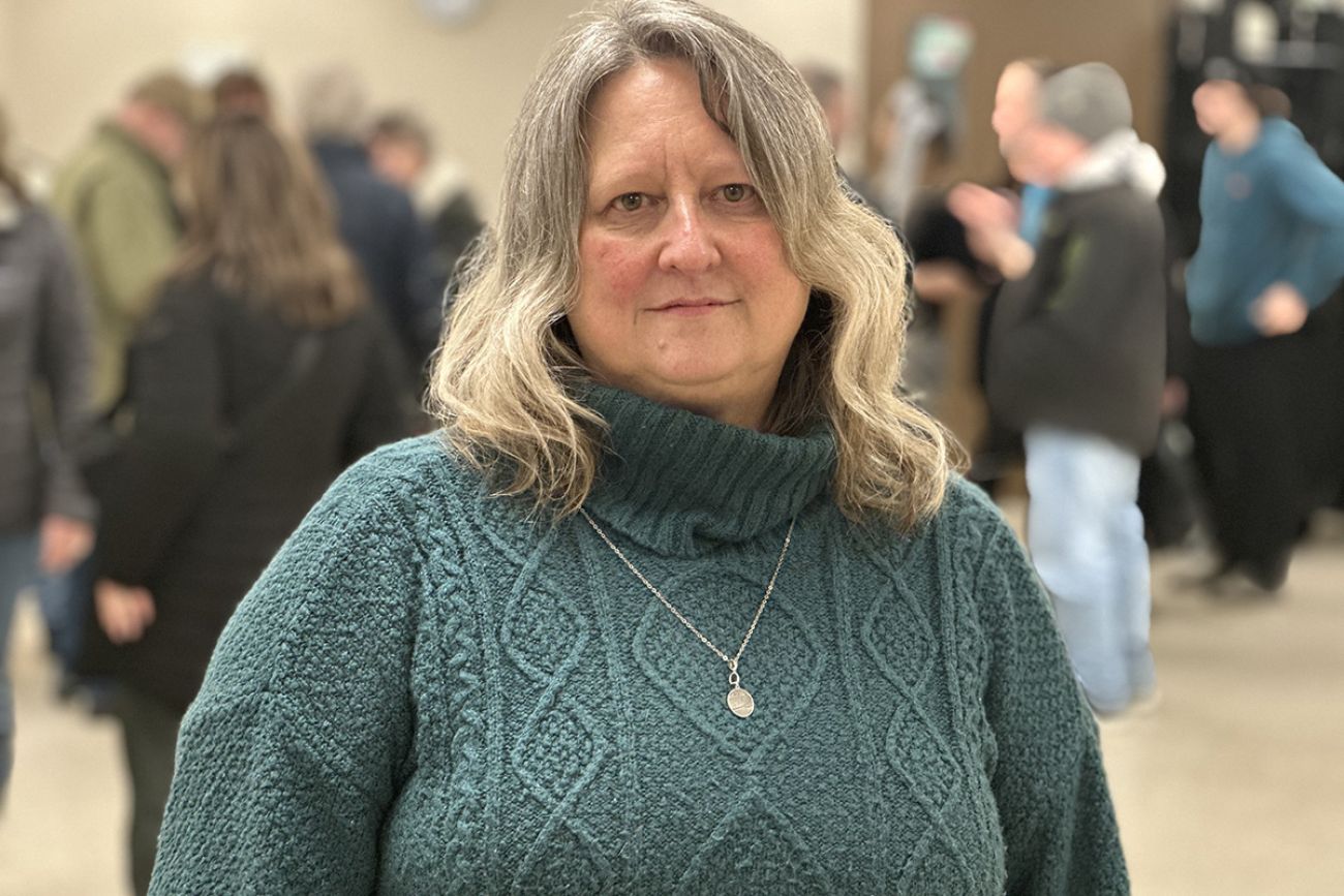Julie Mallard wears a teal knitted-sweater.