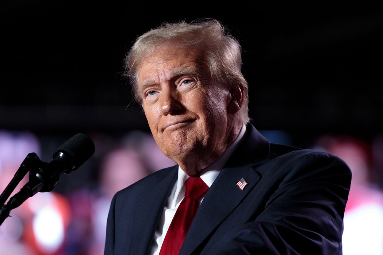President Donald Trump speaks into microphone