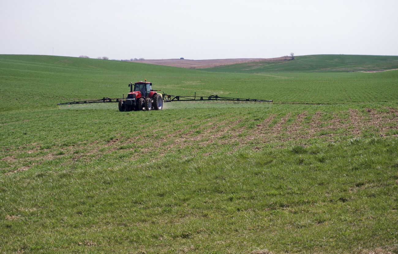 A tractor spraying herbicide in the field.