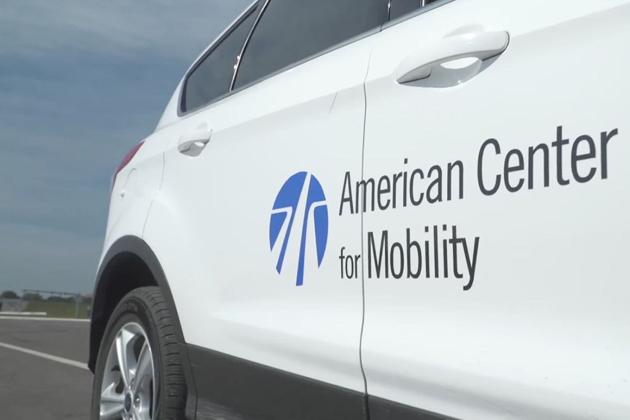 A white car with "American Center for Mobility."