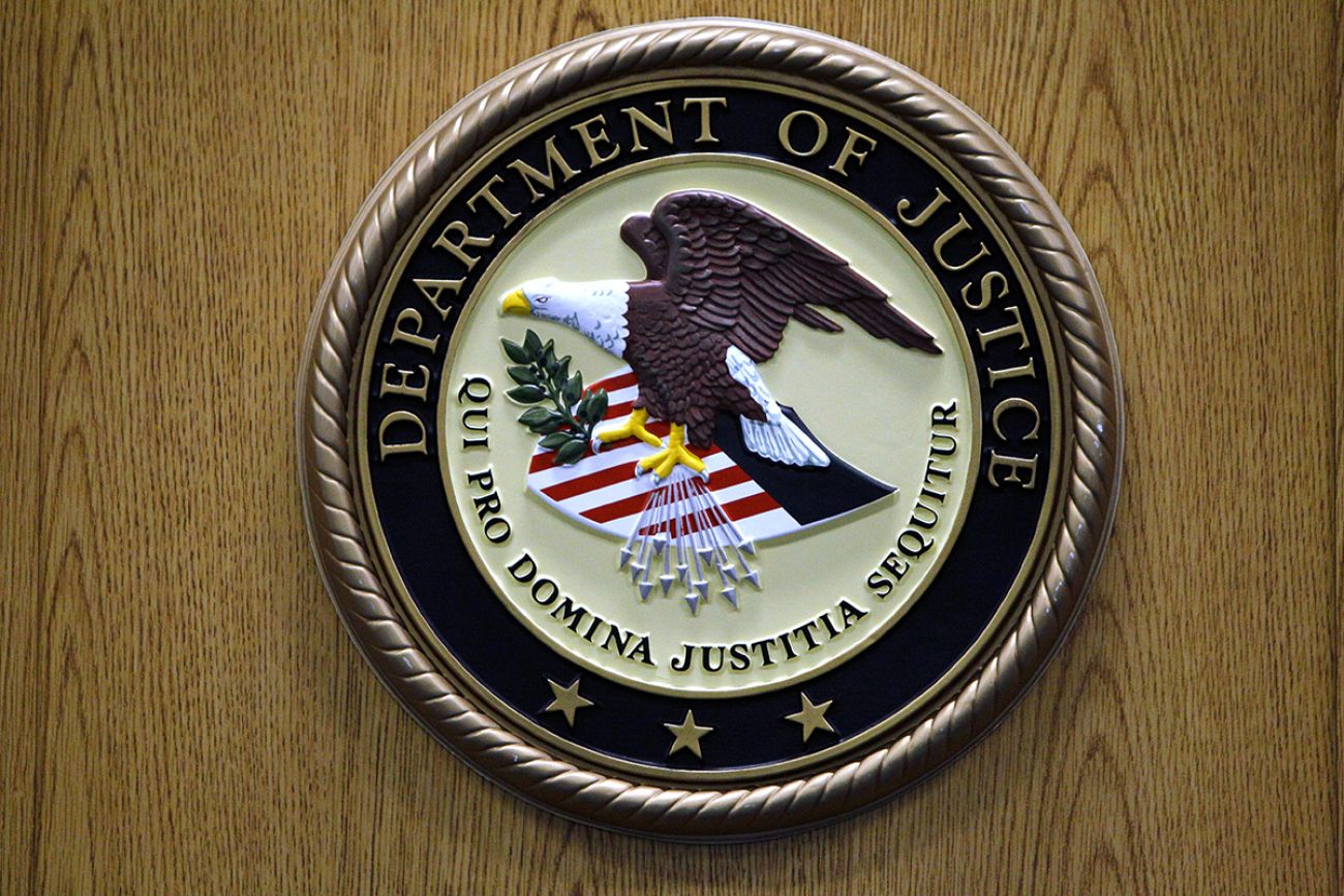 Justice Department logo on the wall. 