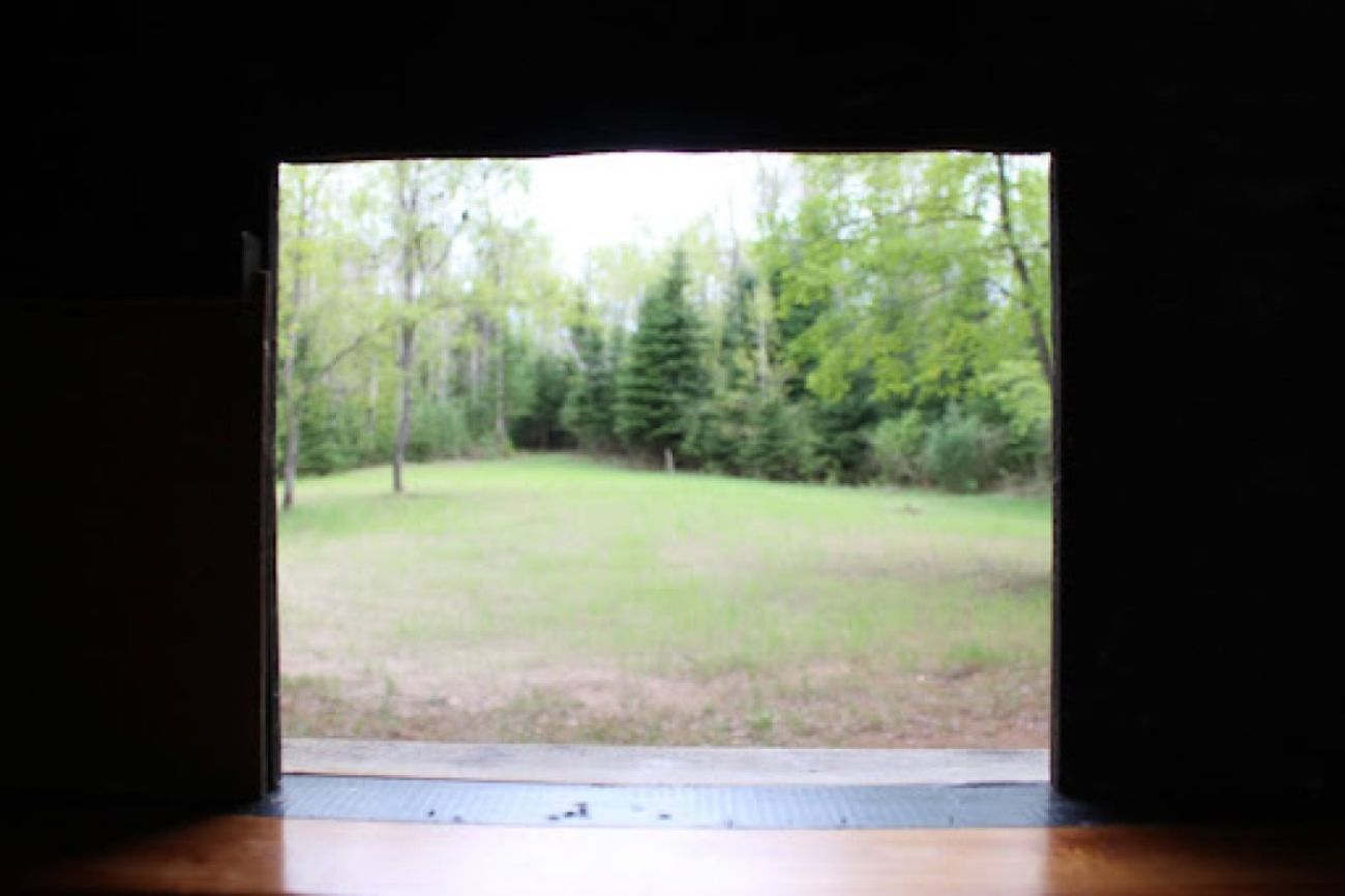 A field is seen through the window of a deer blind in northern Michigan