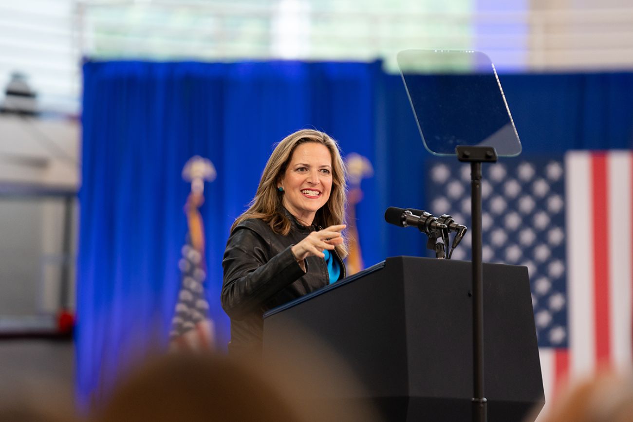 Michigan Secretary of State Jocelyn speaks into a microphone.