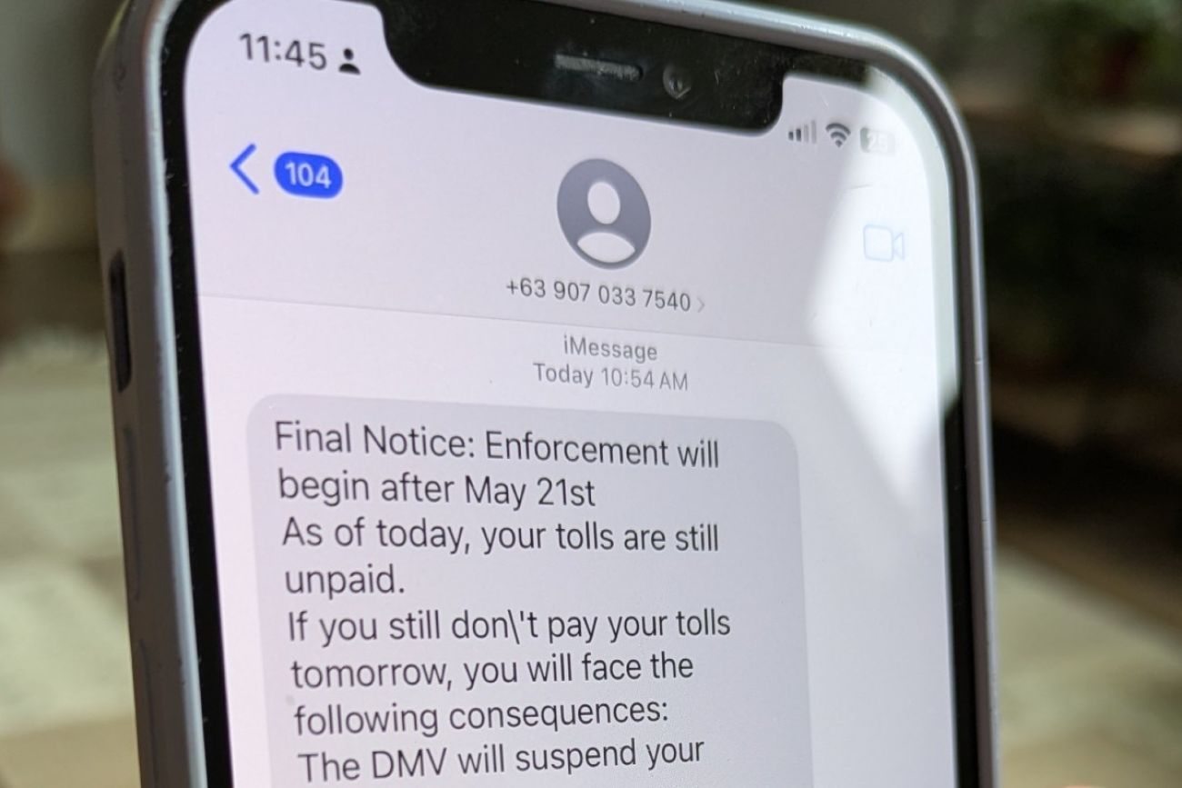 A toll road scam message is seen on a smartphone screen