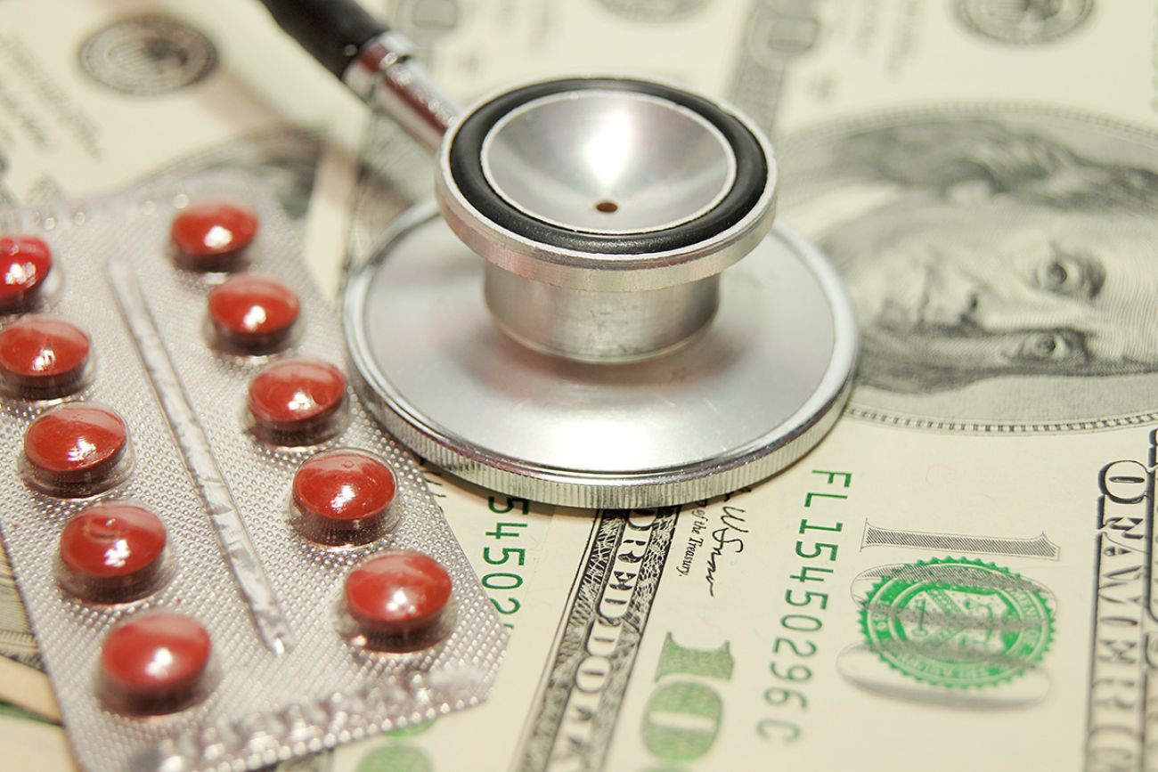 Stethoscope on money background and pills.