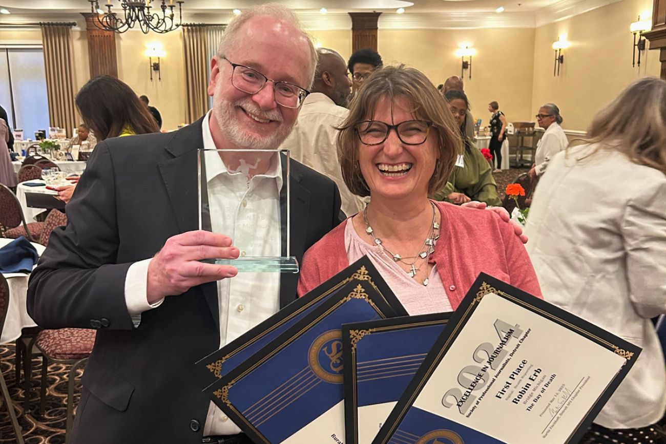 Ron French and Robin Erb smile and hold awards.