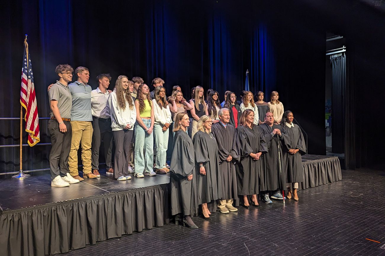 Michigan Supreme Court justices stand in a row. Students are behind them.