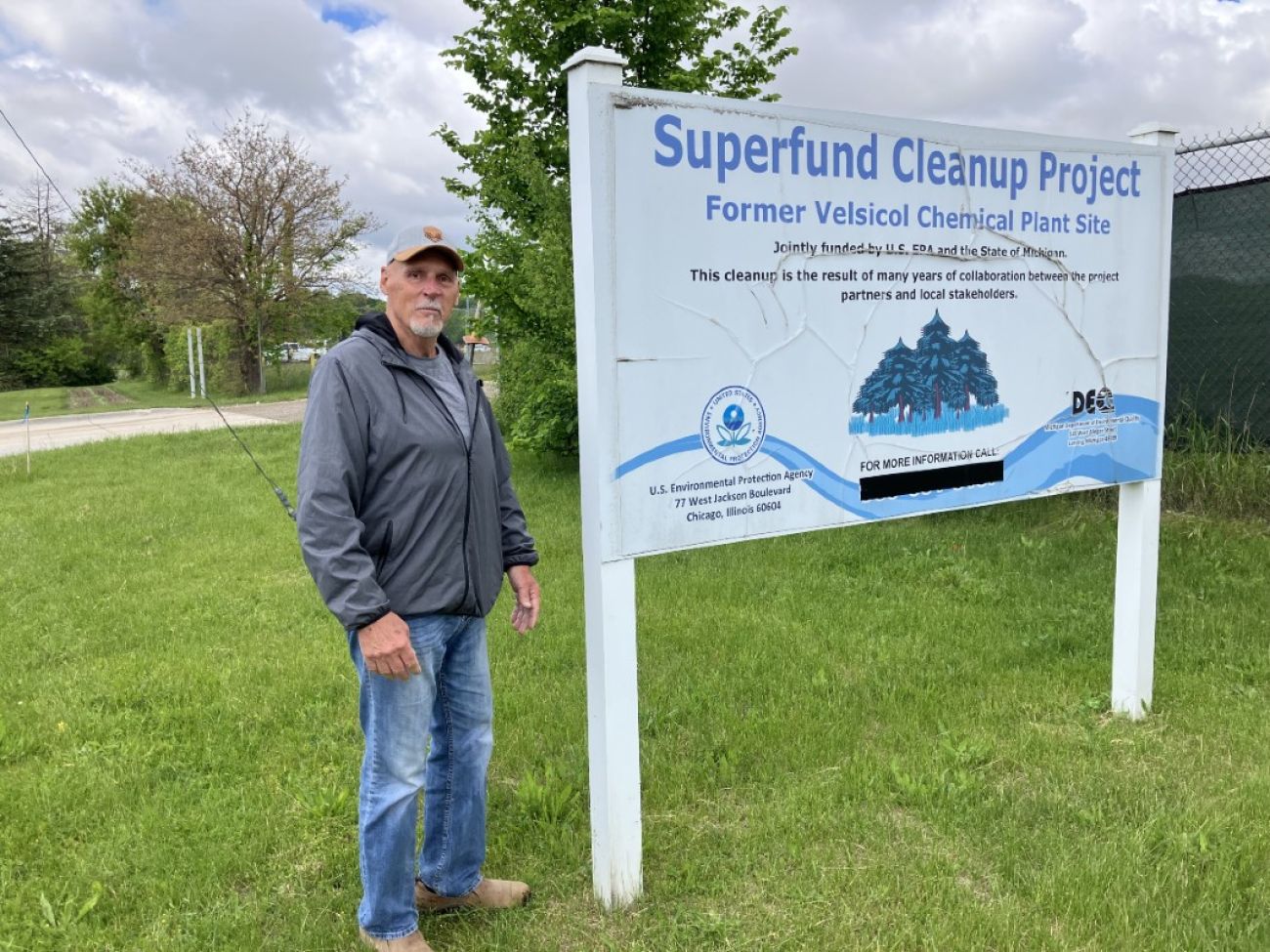 Man stands by sign