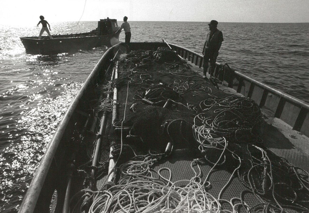 A black-and-white photo of people on a boat.