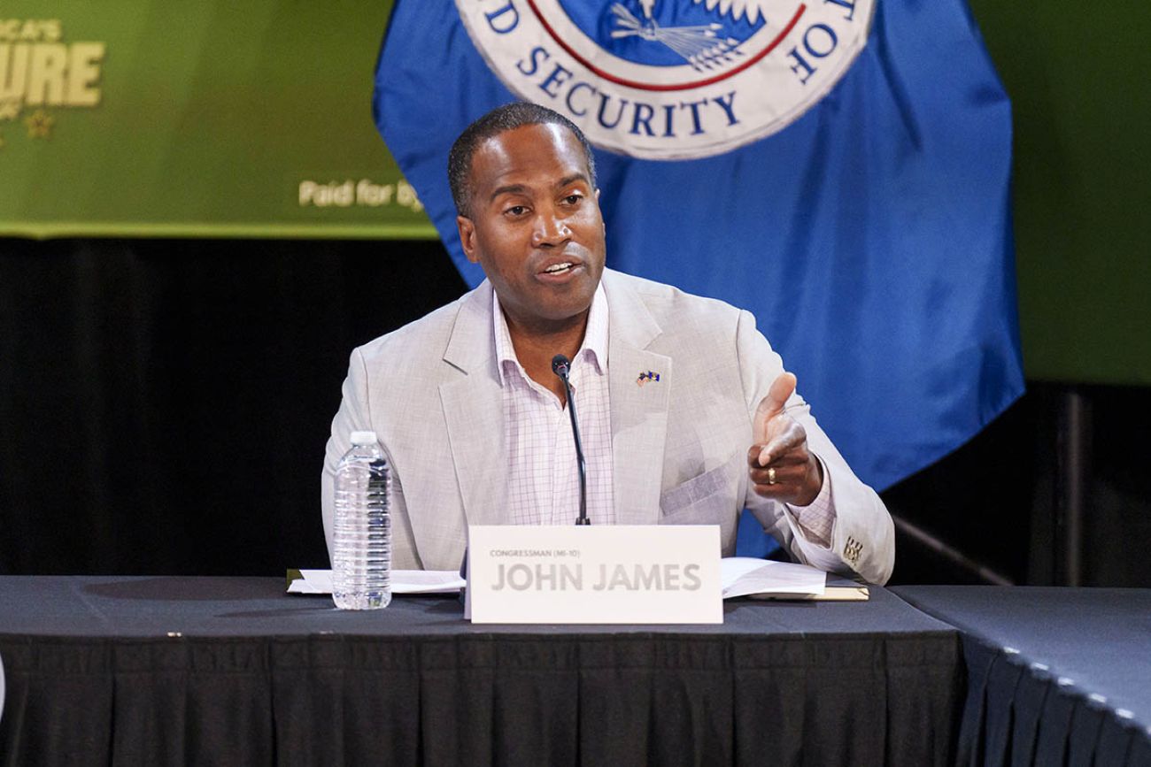 US Rep. John James, R-Shelby Township, sits at a table.
