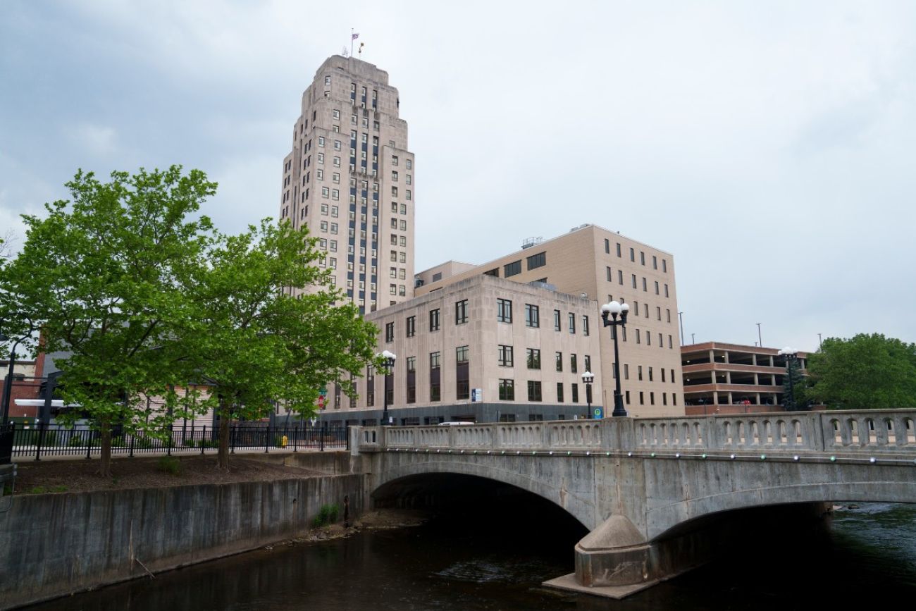 A river flows under a bridge with tall buildings in the background