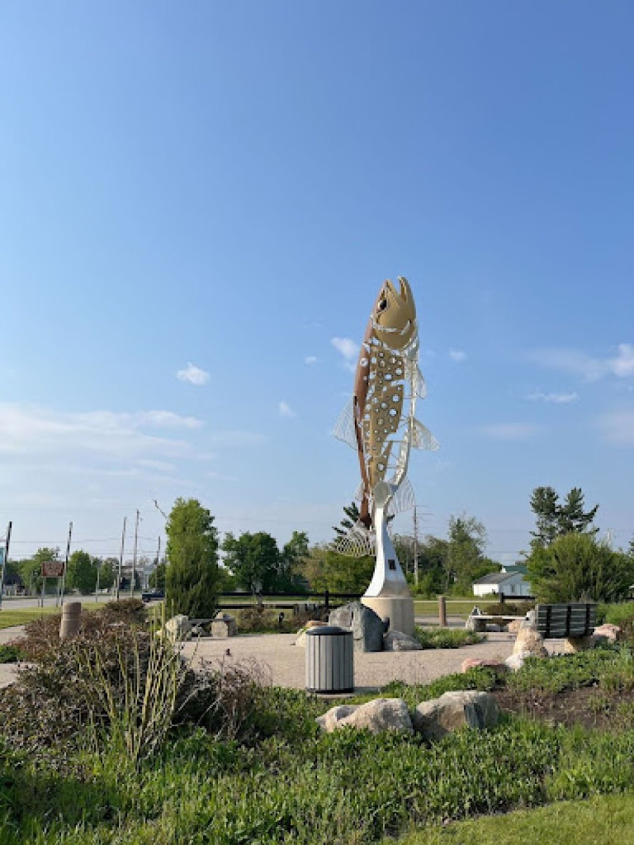 A sculpture of a lake trout sits in a grassy area in Baldwin