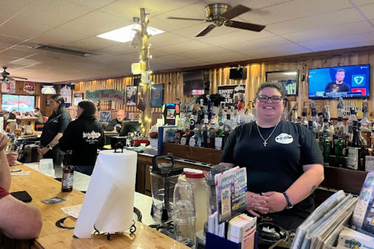 A woman poses for a photo in the middle of a busy bar
