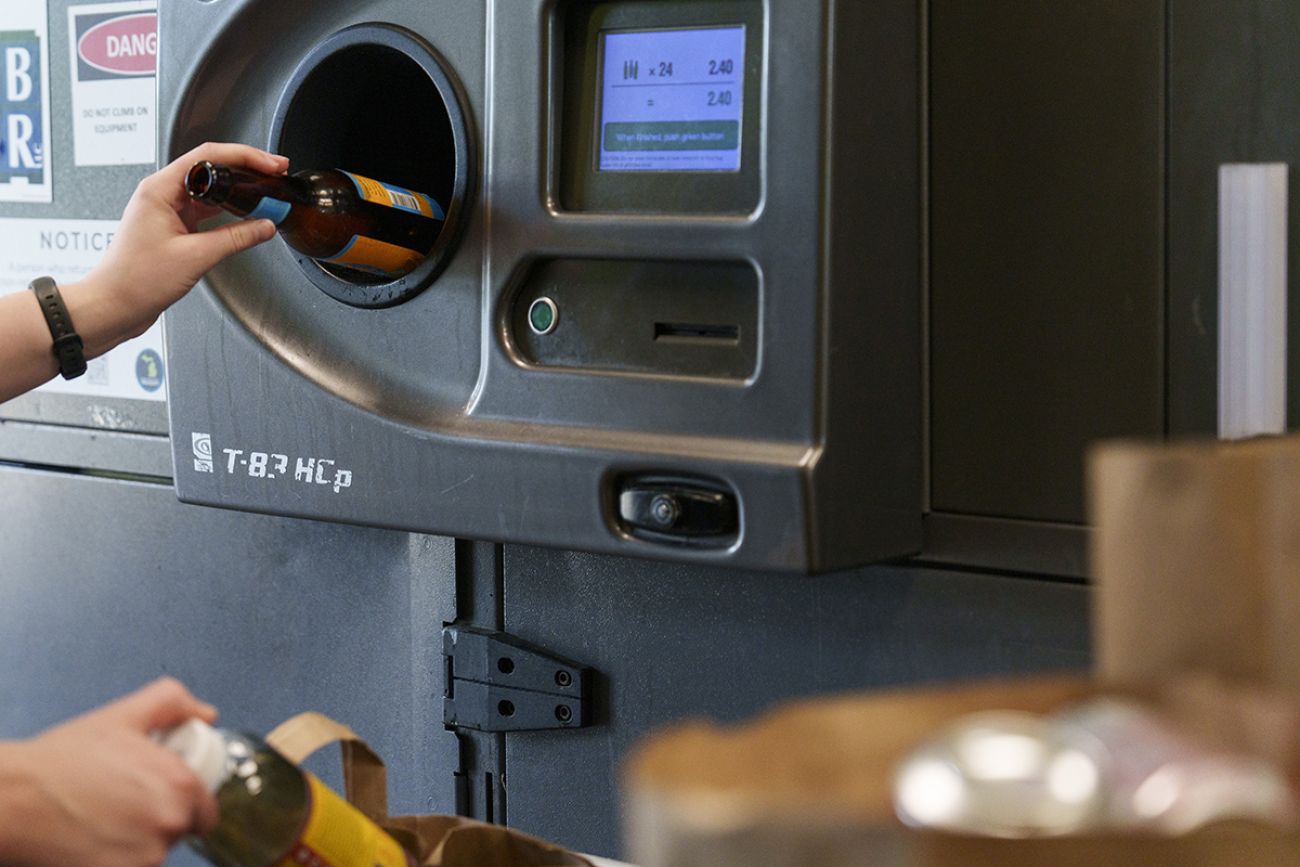 An empty bottle into a bottle deposit.