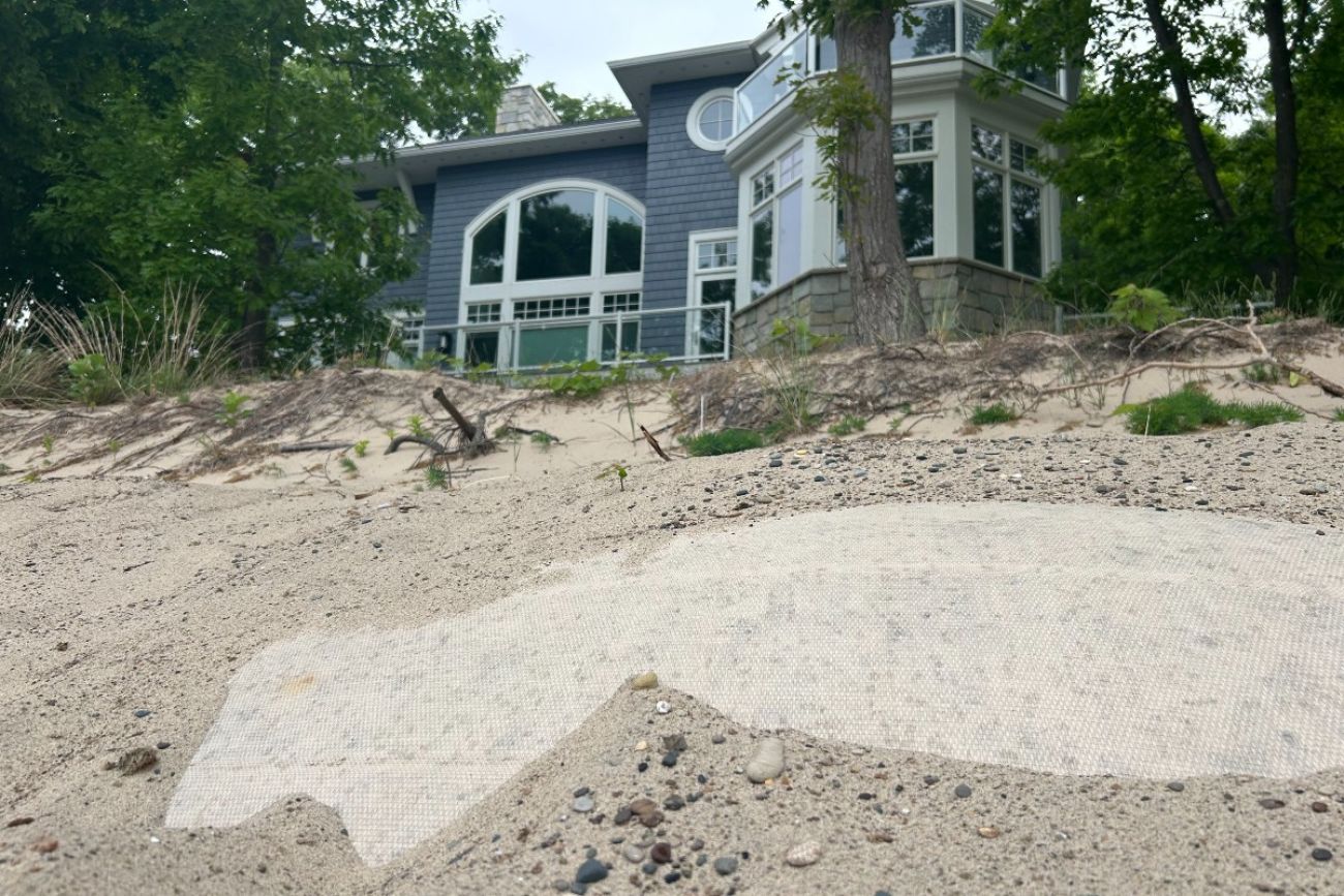 Sandbags are seen in a dune in front of a house