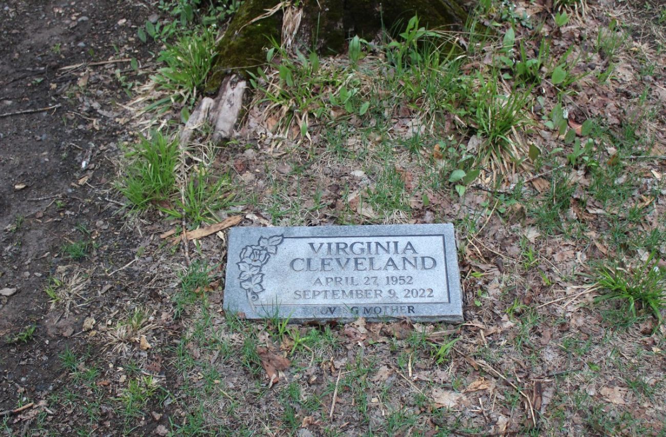 A gravestone sits atop of grass
