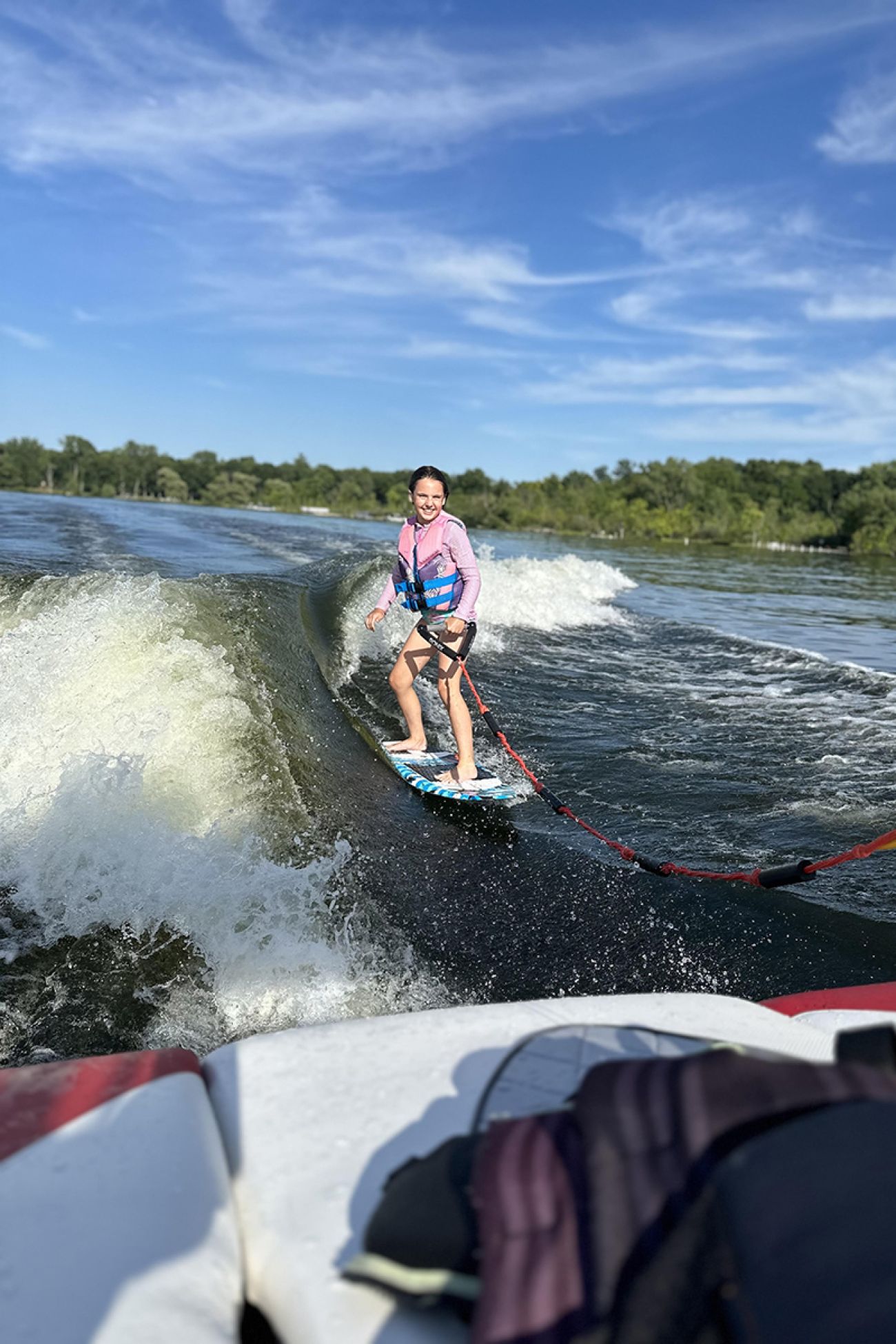 A vertical image of a female wake boarding.
