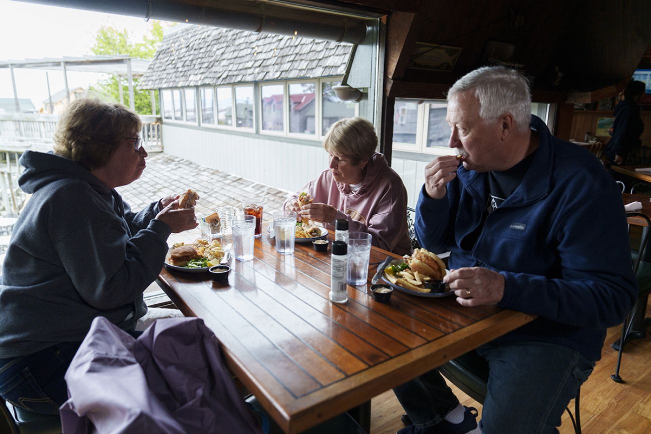 People are eating on a brown table.