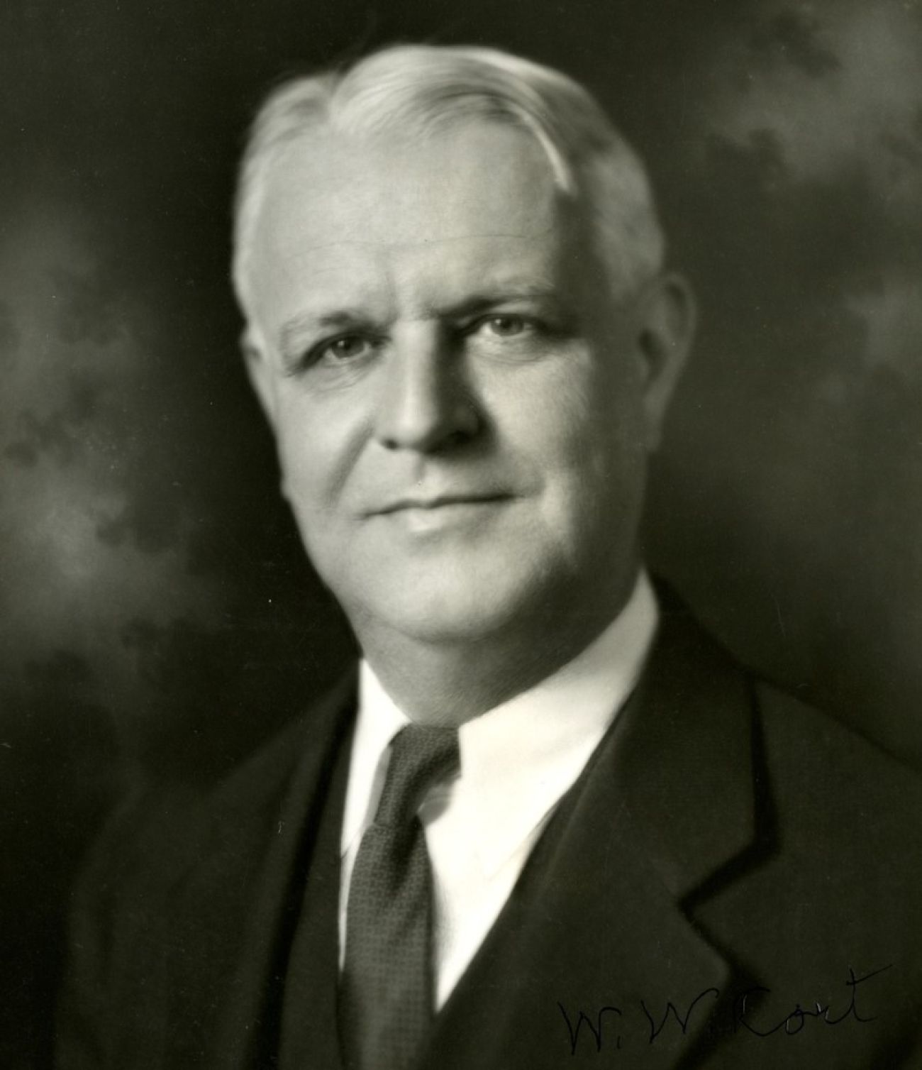 A man poses for a photo in this black and white image