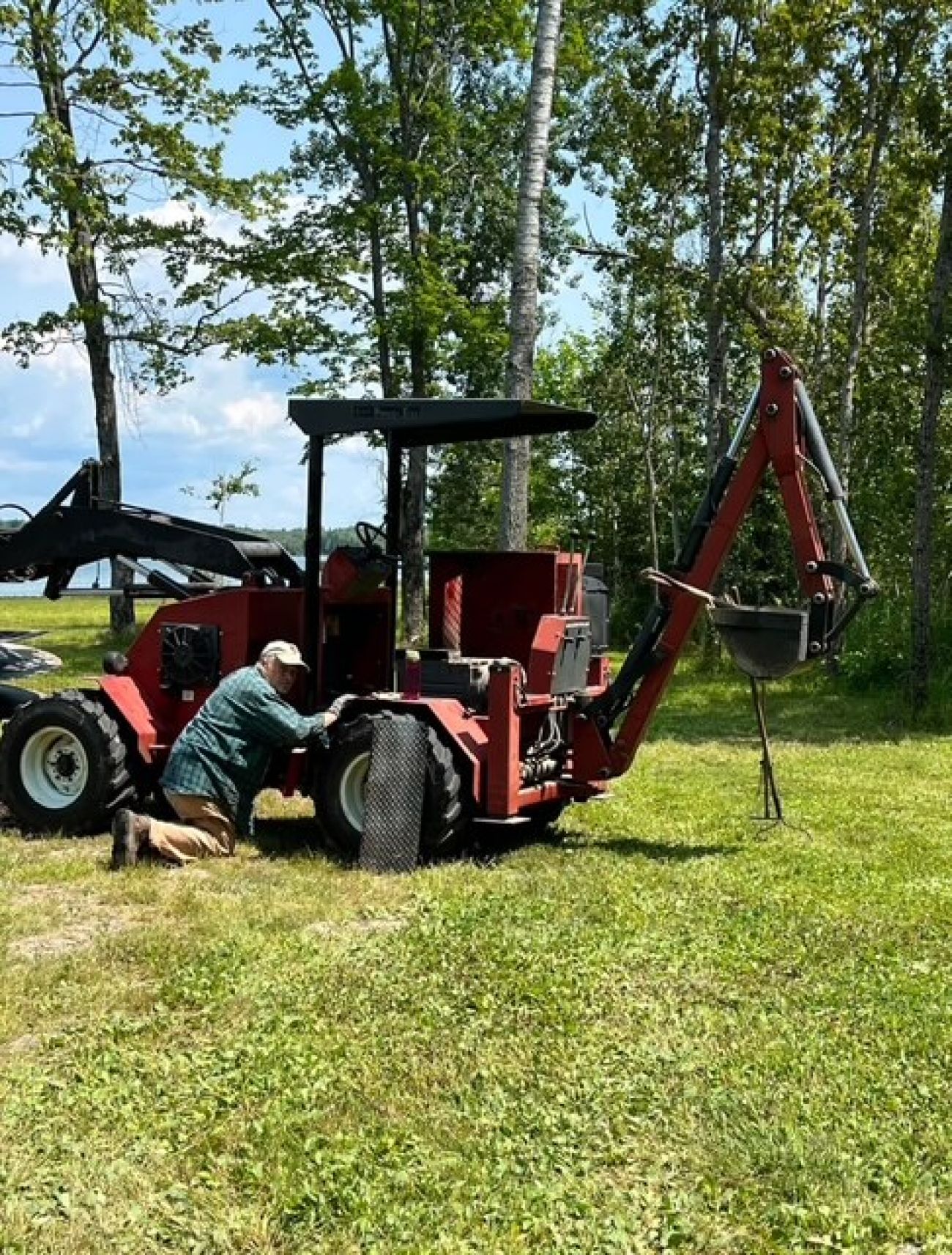 A man by a red tractor.