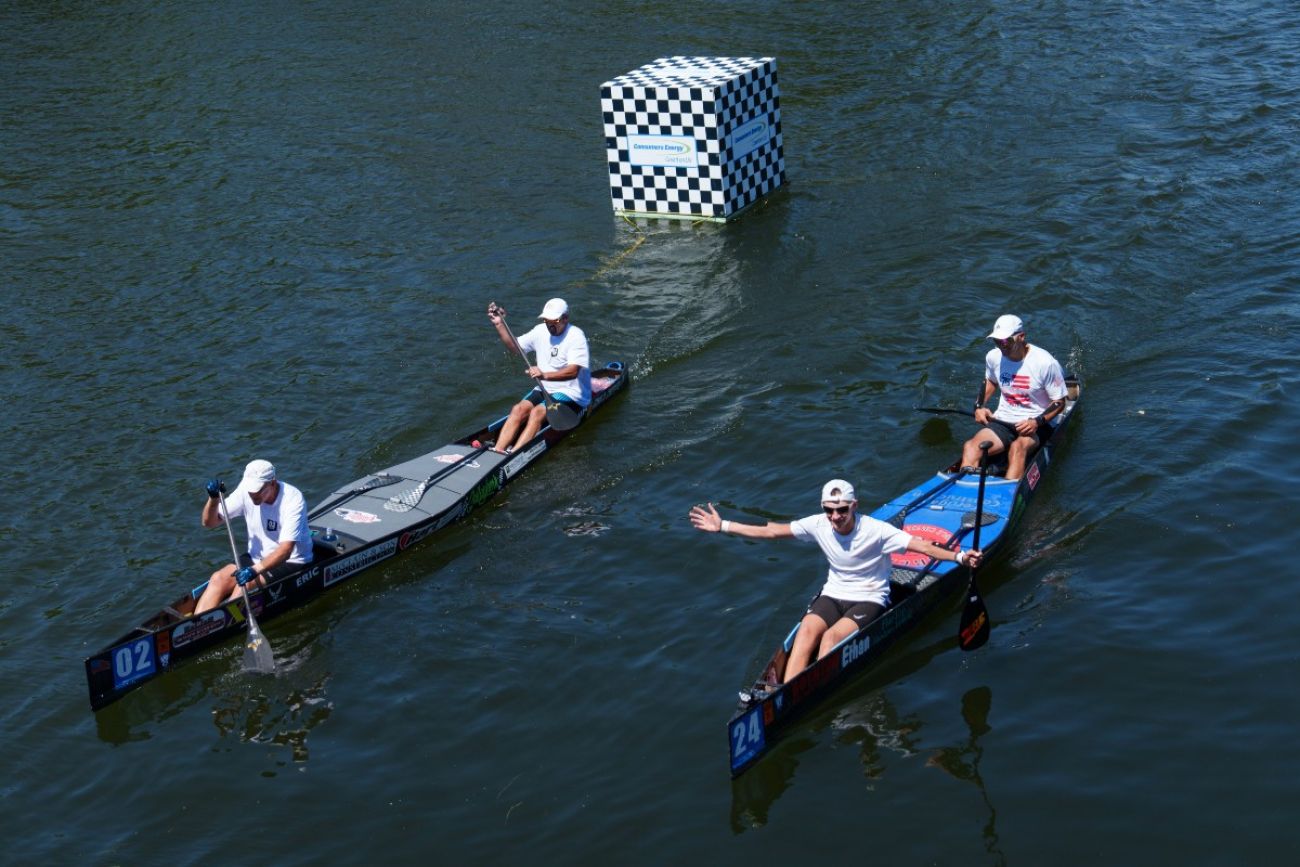 Canoeists paddle down a river during a race