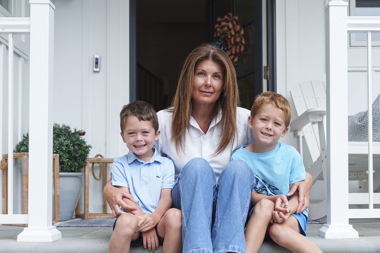 Katie Kerstetter poses for a photo with her children in front of their house.