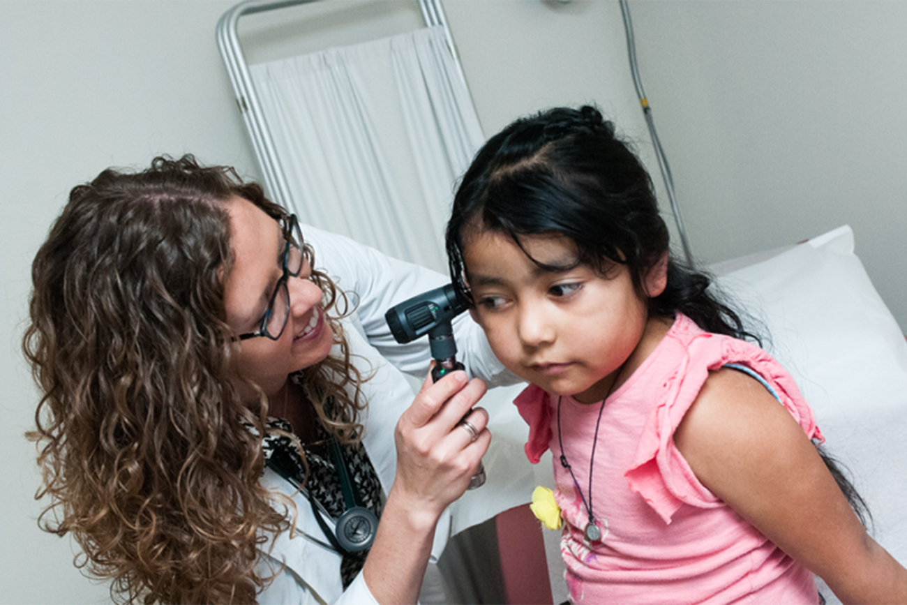 A doctor examines a young girl.