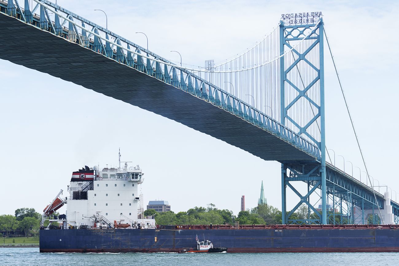 A freighter goes underneath the Ambassador Bridge.