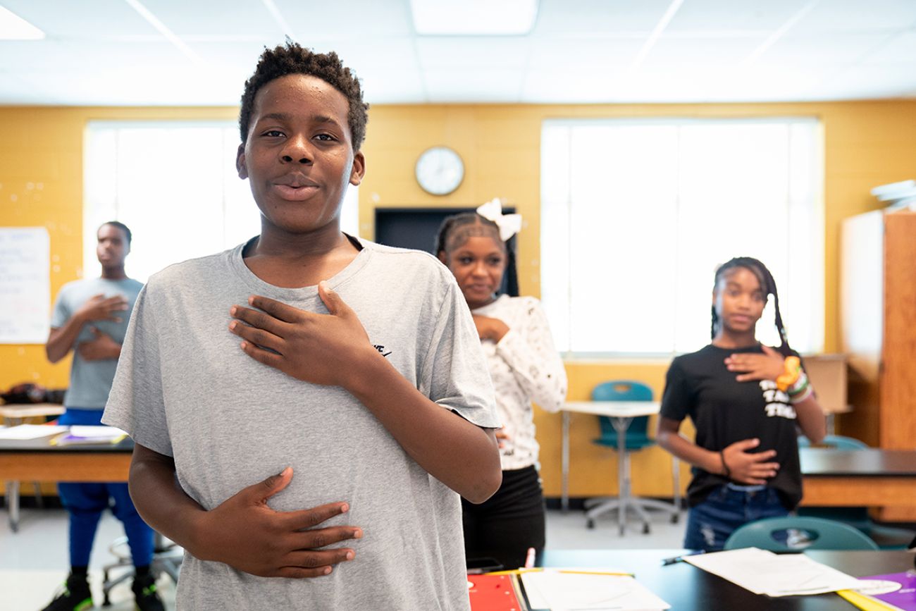Student Trevon Scott holds his hands to his body. Other students are behind him.