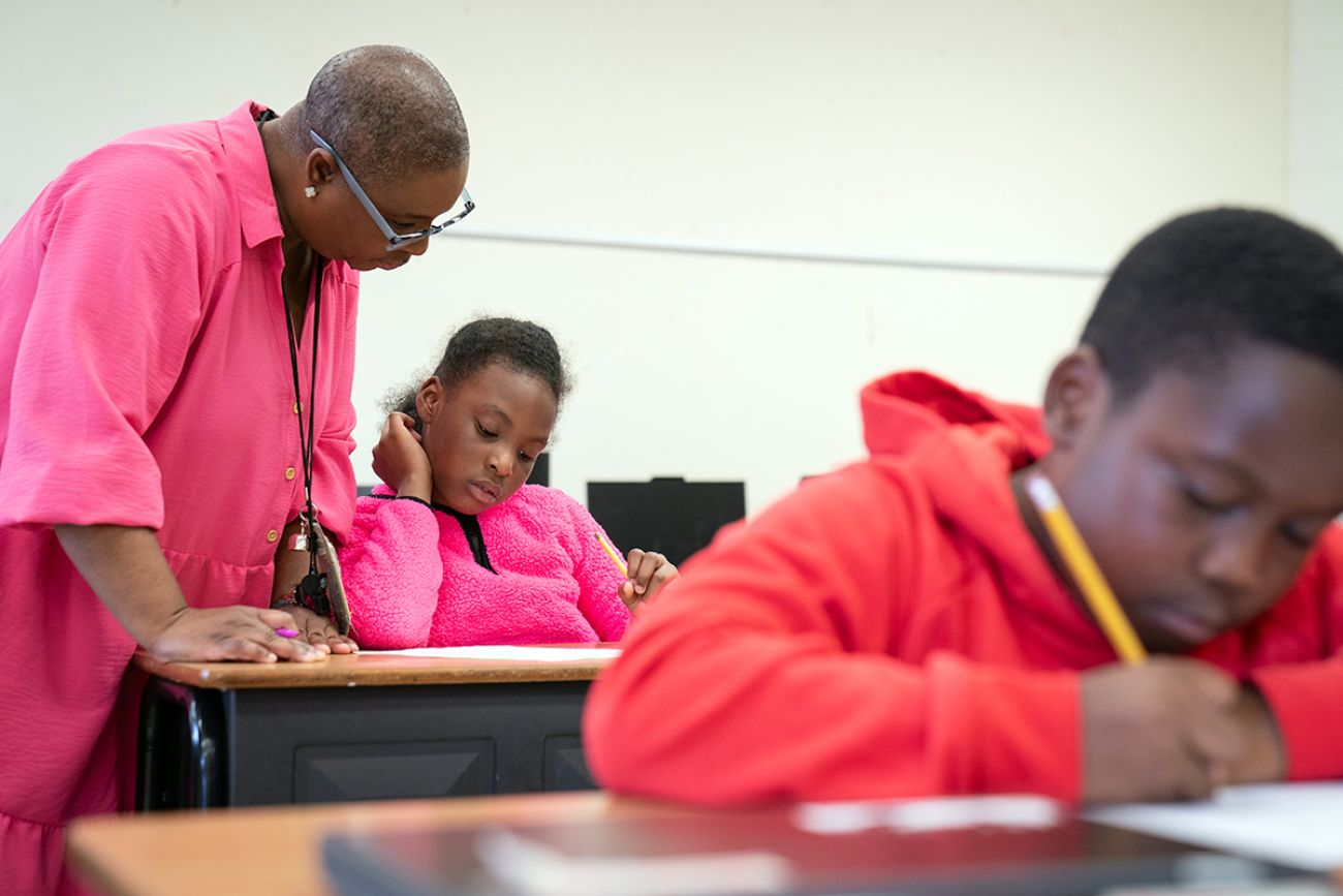 Summer school teacher Amelita Ross looks overs a student's work.