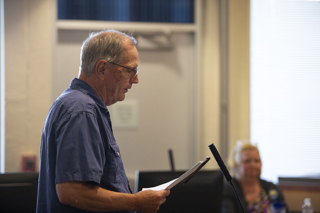 East Grand Rapids resident Jerry Anderson speaks into a microphone.