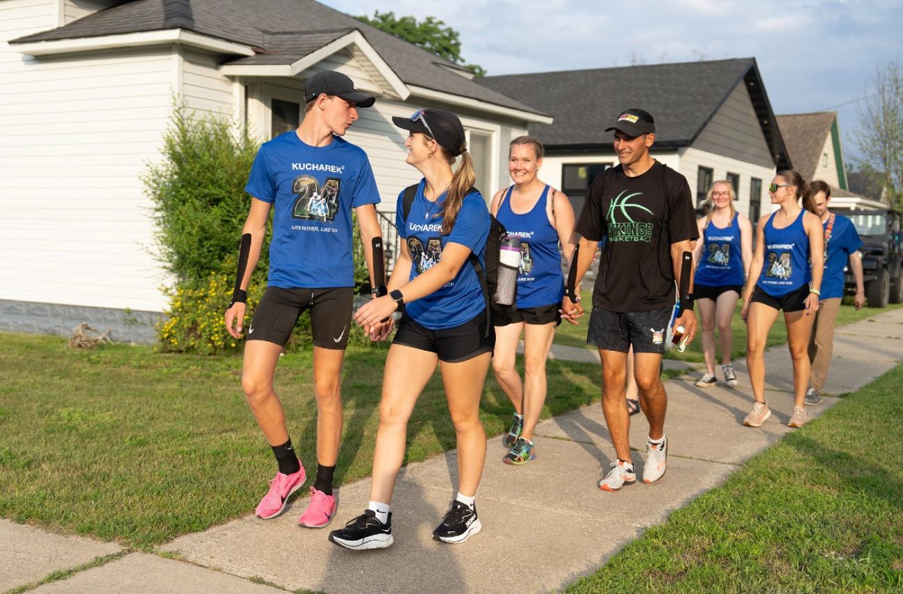 A line of canoe racers walk toward the starting line