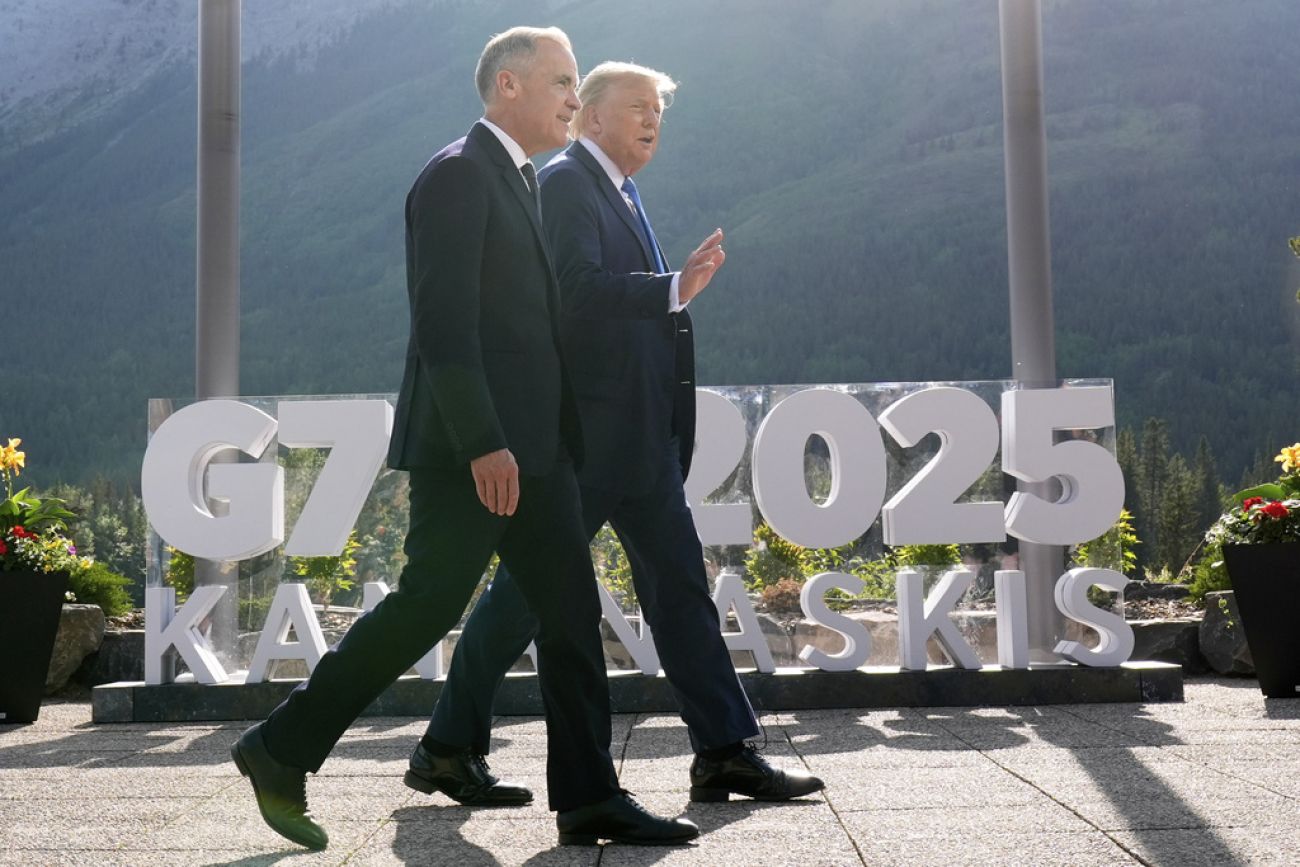 Canada's Prime Minister Mark Carney walks with President Donald Trump.
