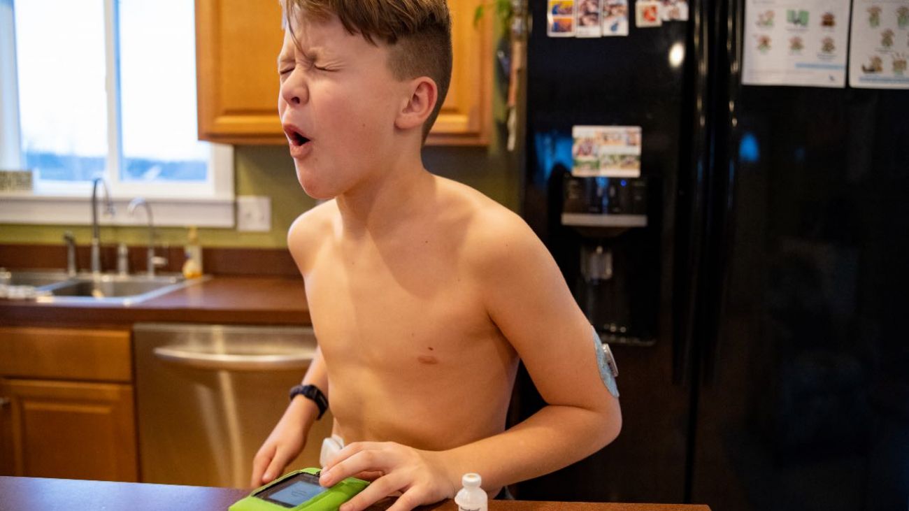 Brady Lockwood, 12, reacts the moment an insulin pump is injected into his bloodstream before dinner