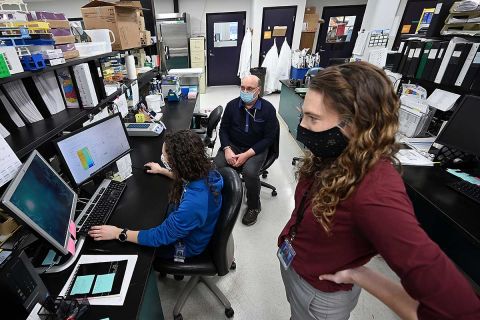 Dr. Heather Blankenship, foreground, Steve Dietrich, and Elizabeth Burgess track coronavirus variants at the Michigan Bureau of Laboratories in Lansing as the variants take hold in Michigan. 