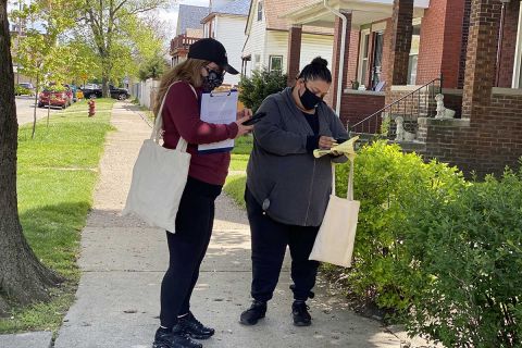 Elizabeth Gonzalez, left, and Nora Rodriguez go door-to-door on Ferdinand Street in Southwest Detroit to promote the availability of COVID-19 vaccines and to let neighborhood residents know where they can get them. 