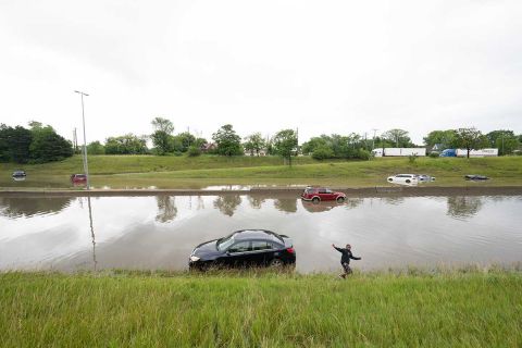 A Detroit child plays near a car on a flooded freeway after Friday night’s storm left thousands of Detroiters with destroyed property and flooded basements. 