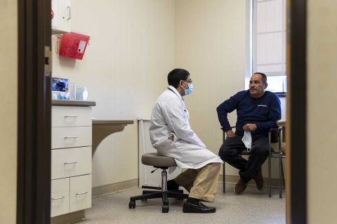 Dr. Sanjoy Mukerjee, left, meets with his patient Porfivio Alvarenga