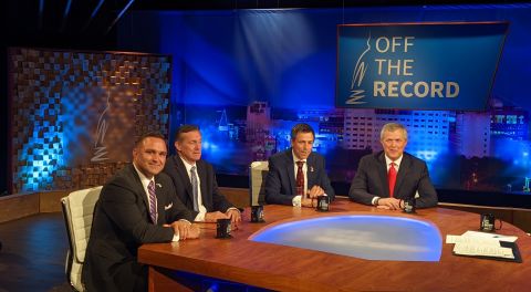 candidates around a table at a TV studio