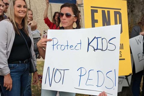 woman holding protect kids sign