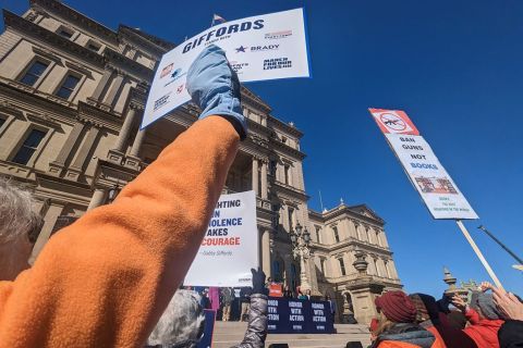 People hold up signs at gun rally