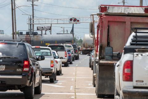 Cars wait as train crosses road