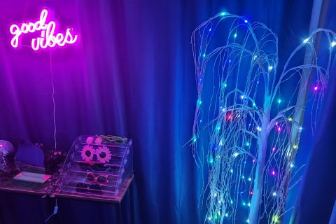 room with blue light with a neon sign that says "sensory room"