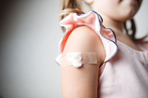 little girl with plaster on the shoulder from the injection