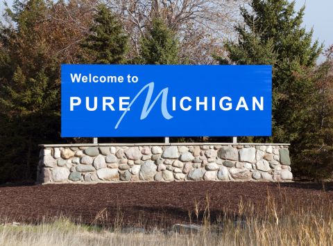 Blue welcome to pure michigan sign on a stone wall 