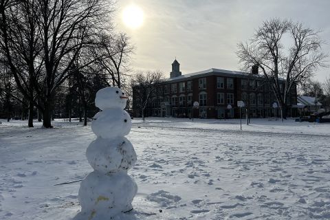snowman in front; school in the background
