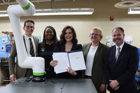 Gov. Gretchen Whitmer standing in a group of people holding paper