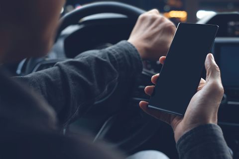 Mock up of man using mobile smart phone inside a car.