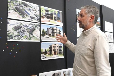 A man looks at building plans pinned up on a wall