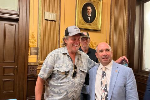 Ted Nugent poses for a photo with a state lawmaker in a hearing room at the Michigan state capitol